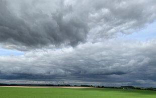 Dramatischer Wolkenhimmel über einem Feld